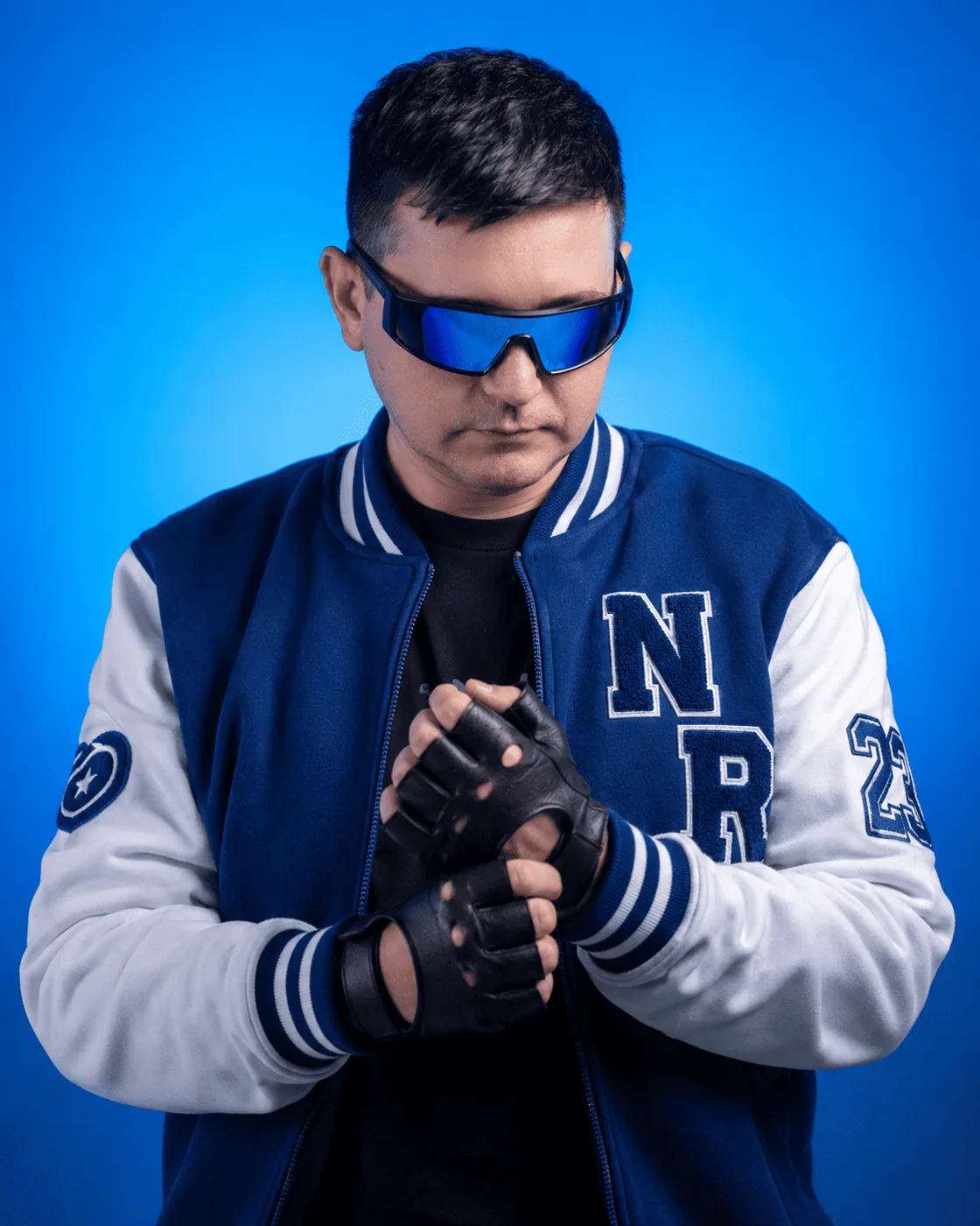 Nyno Ricco de jaqueta college azul em fundo azul